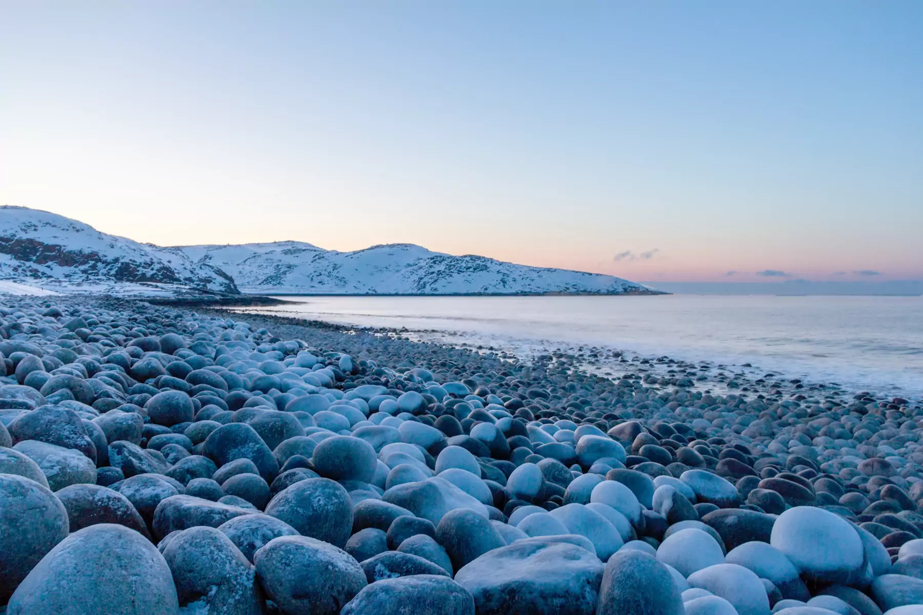 Rundgeschliffene Felsblöcke an einem steinigen Strand