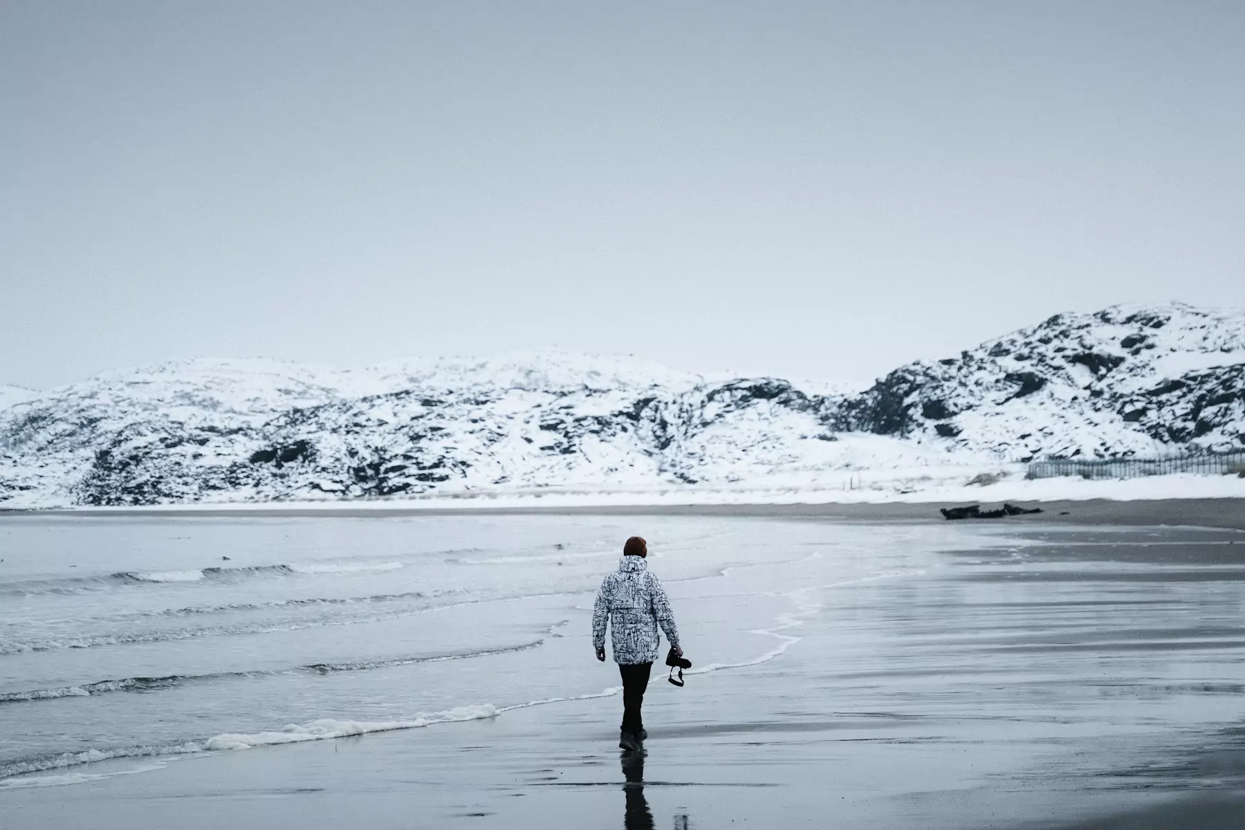 Reisender an einem verschneiten Strand